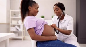 Black doctor treating Black pregnant woman