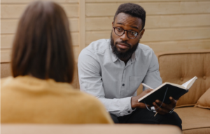 Black male therapist speaks to patient